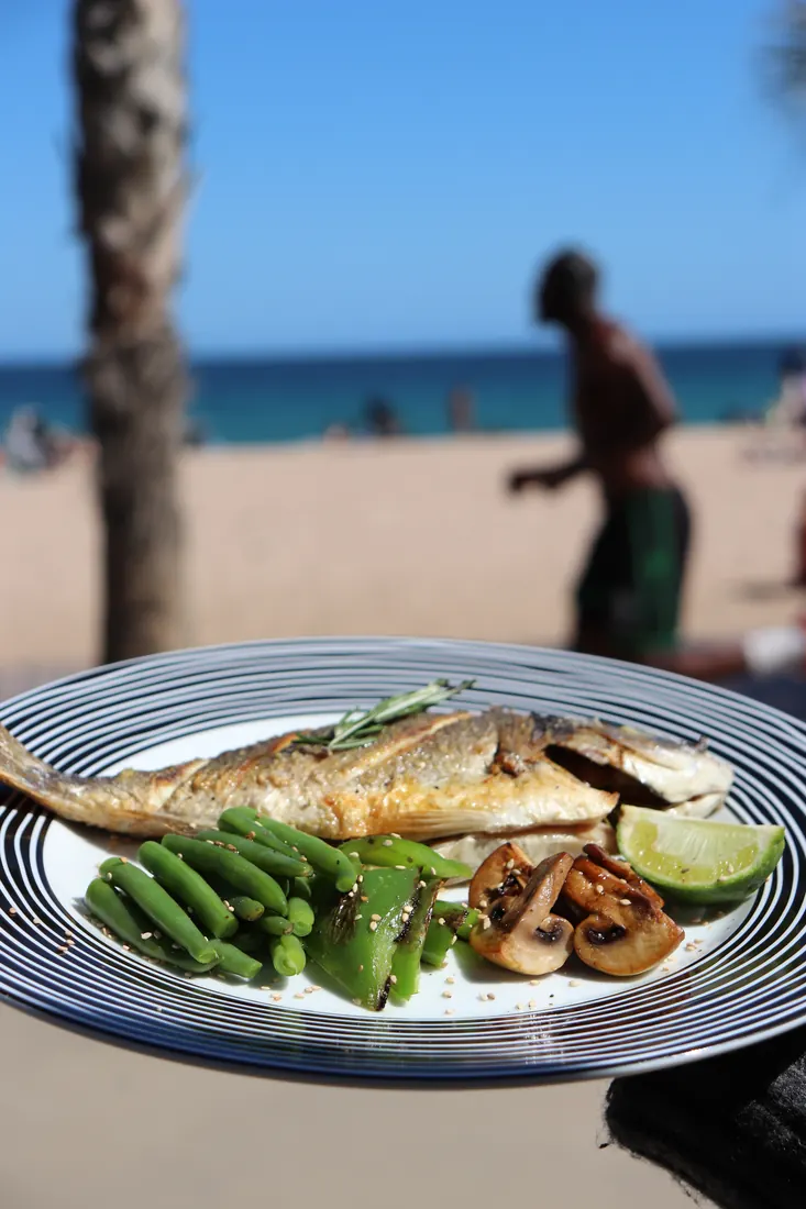 Dorada a la plancha con la playa de Badalona al fondo · Aroma de Mar